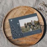 Cartão De Festividades Snowy Pines | Imagem de Natal Elegante<br><div class="desc">Um design de cartão de Natal moderno e elegante,  com uma fotografia horizontal sobre um fundo azul escuro,  enfeitado com pinheiros carregados de neve e revestidos de estrelas brancas. Personalize com seu cartões de natal personalizado,  seu nome de família e o ano.</div>