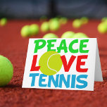 Cartão De Festividades Tênis Love<br><div class="desc">Eu adoro jogar tênis. Um presente de Natal bonito para um jogador de tênis com uma bola amarela de tênis como O in Love. Paz e Tênis escrito em azul e verde.</div>