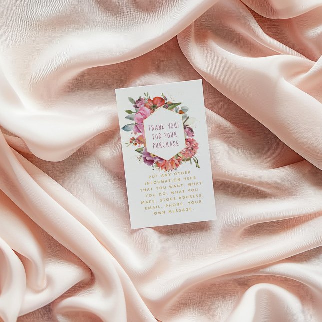 Cartão De Informações Flores e macarons borda dourada (Floral thank-you card with watercolor flowers and gold text, placed on soft blush fabric background)