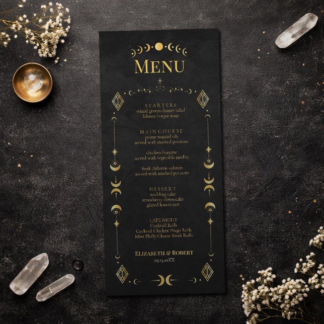 Cartão de Menu de Casamento Preto e Dourado Gótico (Celestial Gothic Black and Gold Wedding Menu Card on an elegant dark table with dry flowers)
