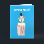 Cartão de Natal, Francês, Cupcake com Snowman<br><div class="desc">Um cartão de Natal francês brilhante e alegre com um boneco de neve decorado e sagrado em cima de um cupcake gelado, de uma colagem de papel pintada à mão por Judy Adamson. A saudação frontal, em texto branco sobre fundo azul, é 'Joyeux Noel!' e a mensagem dentro, que você...</div>