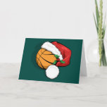 Cartão de Natal para Bonés de basquete<br><div class="desc">Uma bola de basquete vestindo um boné papai noel com primavera de Holly para o Natal. O plano de fundo é verde,  mas a cor de fundo pode ser alterada clicando em "Personalizar". Dentro do cartão estão as palavras "feriados felizes" que também podem ser personalizados.</div>