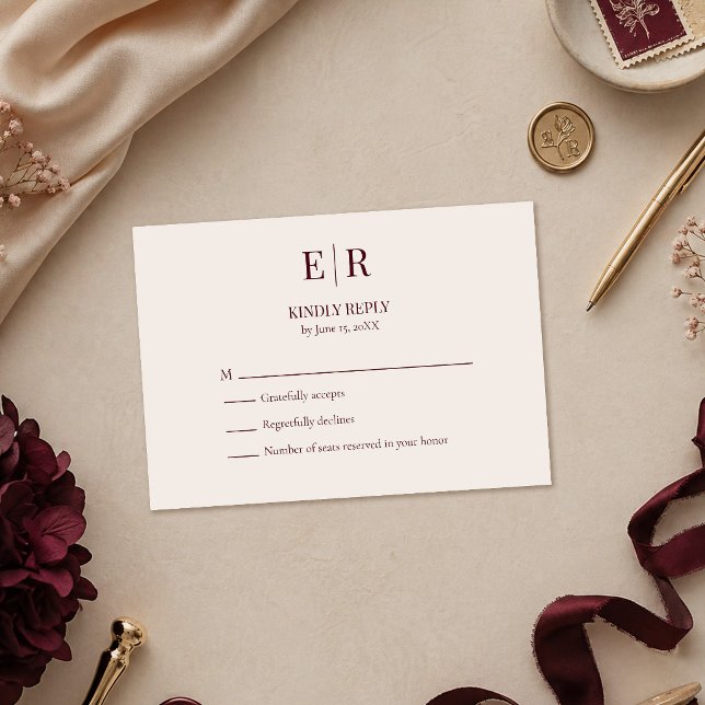 Cartão de Resposta de Casamento com Monograma Burg (Elegant Burgundy Monogram Wedding RSVP Card on a table with burgundy and gold wedding decoration)