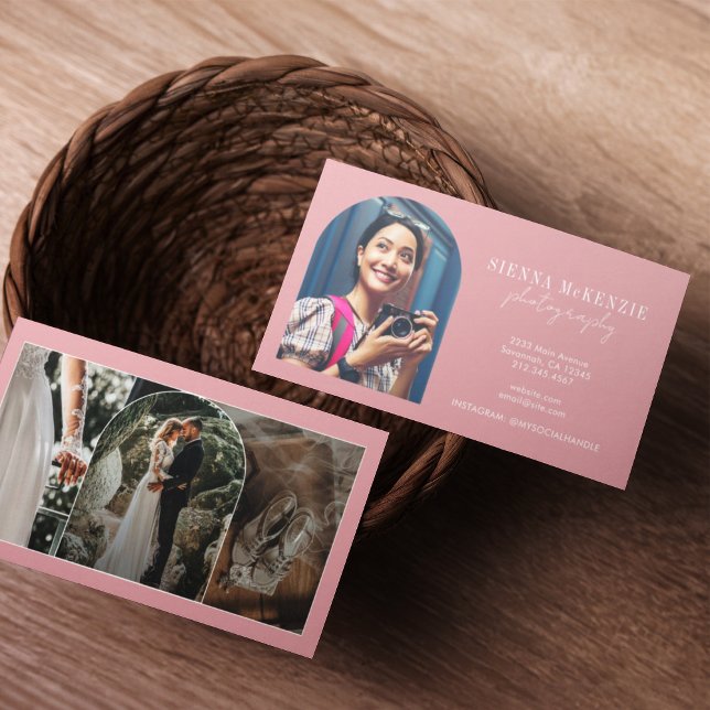 Cartão De Visita Fotografia de Script de Arco Moderno Profissional (Two business cards in a woven basket on a wooden table. One card shows a smiling woman with a camera)