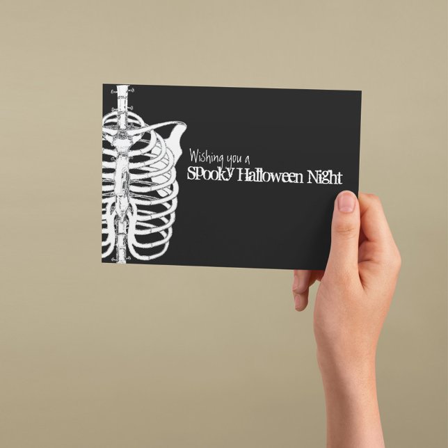 Cartão Esqueleto Assustador Halloween Preto e Branco (Spooky Halloween greeting card with skeleton illustration and gothic black background.)