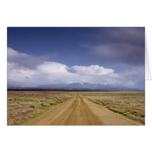 Cartão EUA, Utah, estrada Dirt atravessando paisagem