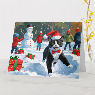 Cartão Gato Tuxedo Correndo na Neve com Chapéu de Natal