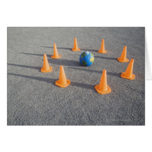 Cartão Globo sobre areia ao ar livre rodeada pelo trânsit