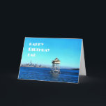 Cartão Happy Birthday Dad Over Ocean Lighthouse Card<br><div class="desc">A strong sturdy lighthouse watches over the city in the foreground. in the background it's a nice sunny day and lovely blue skies with the odd cloud in the sky. This birthday card is the perfect,  cheerful and inspiring way to celebrate the birthday of a father. Happy Birthday Dad!</div>