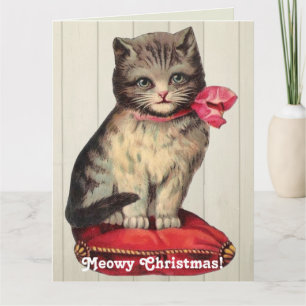 Cartão Kitten Natal Sentado Vestindo um Arco Vermelho