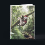 Cartão Lã De Natal Na Floresta Tropical<br><div class="desc">Uma preguiça vestindo um chapéu de Papai Noel vermelho e branco e um cachecol vermelho pendura confortavelmente de um galho no meio de uma floresta verde e luxuosa</div>