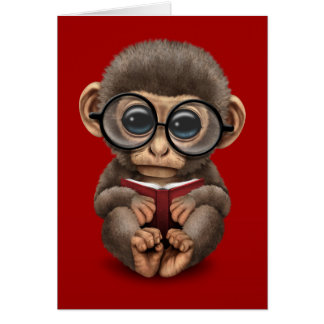 Cartão Macaco bonito do bebê que lê um livro no vermelho