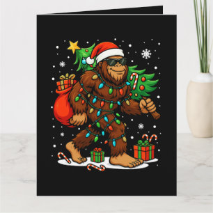 Cartão Papai Noel Bigfoot Engraçado Carregando Árvore de
