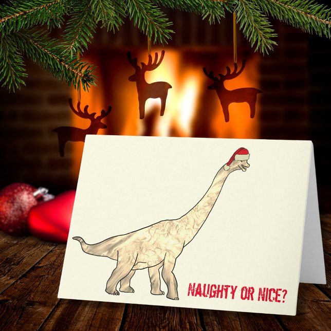 Cartão Papais noeis Brachiosaurus Engraçado Citação de Na (Funny Christmas dinosaur wearing a Santa hat with naughty or nice quote)