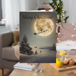 Cartão Papais noeis De Vintage Sob Rena Voadora De Lua Co<br><div class="desc">Este é um velho cartão de Natal da década de 1960, feito de novo através da magia de Zazzle. O cartão mostra Papais noeis e sua rena debaixo de uma lua de cheio. O enorme pinheiro e solitário na cena, deixa um com um sentimento de maravilha e encantamento da época...</div>