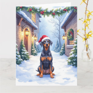 Cartão Pinscher Alemão com Chapéu de Papai Noel no Pátio