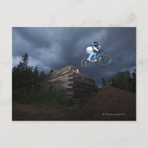 Cartão Postal A mountain biker jumps off a log cabin in Idaho.