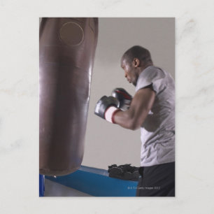 Cartão Postal Boxer usando saco de punção na academia