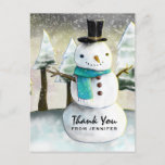 Cartão Postal Brincadeira Snowman Winter Scene Christmas Obrigad<br><div class="desc">Obrigado postal com um desenho bonito com um boneco de neve vestindo um chapéu legal e um cachecol. O fundo tem uma linha de pinheiros brancos cobertos de neve.</div>