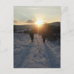 Cartão Postal Casal caminhando na neve ao pôr do sol