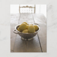 Colander com limões em mesa de madeira