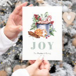 Cartão Postal De Festividades Cartão-postal de Férias de Natal com Cores-d'Água<br><div class="desc">Este aconchegante cartão postal apresenta uma ilustração aquosa das tradicionais guloseimas de Natal, incluindo uma caneca de chocolate quente, uma cana-de-açúcar, uma laranja, um monte de gemas de canela, e um biscoito em forma de estrela fosco, decorado com folhas e frutos sagrados. A palavra "JOY" aparece em letras grandes, azuis-esverdeadas,...</div>