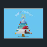 Cartão Postal De Festividades Funny Seas and Greetings Photo Beach Christmas<br><div class="desc">Wish them Seasons Greetings this holiday season with this funny and cute photo blue beach Christmas card with the greeting, "Seas & Greetings" in arched font featuring a white sandy beach, red beach umbrella, and seascape inside of a whimsical Christmas tree! Inside of the card features your photo, and the...</div>