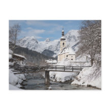 Igreja na neve com montanhas alpinas no inverno