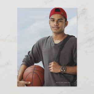 Cartão Postal jovem com boné vermelho segurando bola de basquete