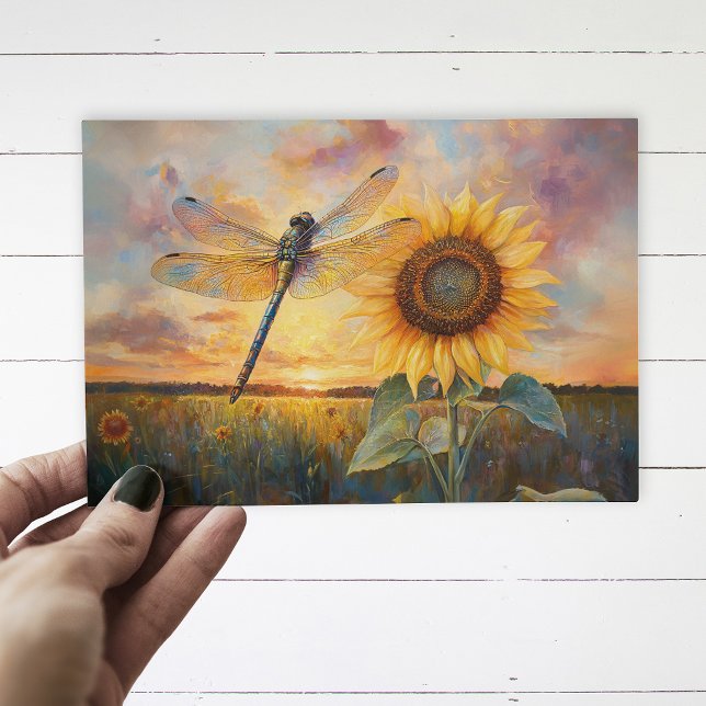 Cartão Postal Libélula Iridescente Girassol Rústico (Postcard with a dragonfly and a sunflower being held up by a hand, over a white wood background.)