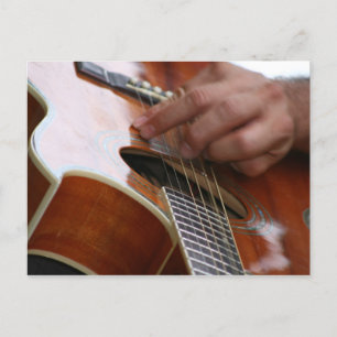 Cartão Postal mão masculina segurando palito na guitarra acústic