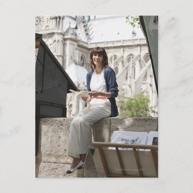 Cartão Postal Mulher lendo um livro numa banca de livros, Notre  (Frente)