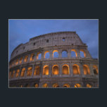 Cartão Postal Roman Colosseum à noite<br><div class="desc">Uma fotografia marcante do colosso romano,  que é um antigo marco em Roma,  Itália. Um ângulo e uma perspectiva interessantes. Tiro à noite com os arcos iluminados e a laranja brilhando. O céu tem nuvens escuras e azuis.</div>