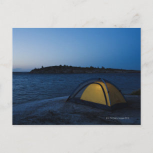 Cartão Postal Tenda iluminada por mar ao anoitecer