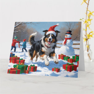 Cartão Rough Collie Correndo na Neve com Chapéu de Natal