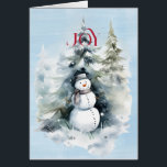 Cartão Snowman in the Forest com Red JOY<br><div class="desc">Uma bela imagem de um boneco de neve na floresta,  com uma alegria vermelha que te atinge. Tudo em um fundo de aquarela azul. Dentro é FÉRIAS FELIZES em vermelho e melhores desejos para o Ano Novo em preto</div>