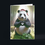 Cartão Urso de Panda de Natal com Coração<br><div class="desc">Um panda fofo vestindo um chapéu de Papai Noel forma uma forma cardíaca com suas patas enquanto sentado numa exuberante floresta de bambu</div>