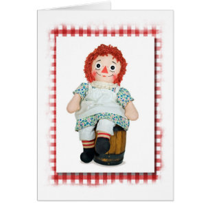 Cartão velha boneca de pano em barril de madeira