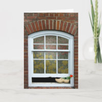 wooden shoe with tulip in window
