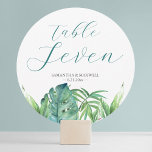 Cartões de Mesa de Casamento de Destino Verde Trop<br><div class="desc">Este cartão de mesa de praia pode ser personalizado com o nome da noiva e noiva e a data do casamento. O número da tabela é definido em uma tipografia de script escrita à mão contemporânea em verde esmeralda com uma pálpebra inferior e folhas monstera em tons de verde. Perfeito...</div>