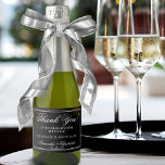 Casamento Minimalista Obrigado White em Black Mini<br><div class="desc">Celebrar em estilo com estas belas minisetiquetas de garrafa de vinho espumante. Essas etiquetas apresentam um estilo minimalista que é simples e elegante com um fundo preto, a letra branca antiga lida na caligrafia: Obrigado por comemorar conosco. Há espaço para os nomes do casal, a data do casamento e o...</div>