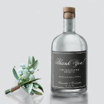 Casamento Simples de Elegância Obrigado Branco em<br><div class="desc">Celebre em estilo com as etiquetas de garrafas de licor de casamento. Projetados tendo em mente o minimalismo, eles apresentam simples letras brancas em um fundo preto com uma borda de quadros. O texto diz: Obrigado por celebrar conosco. Há espaço para os nomes da noiva e do noivo, a data...</div>
