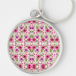 Chaveiro A round keychain featuring a colorful floral