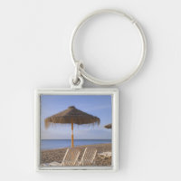 Cadeiras de praia da areia com guarda-chuva