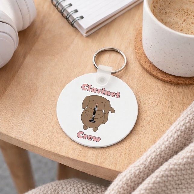Chaveiro Equipe de Clarinete Fofa Músico Cachorro Marrom De (A key chain with a cute dog playing the clarinet and the text Clarinet Crew in pink letters.)