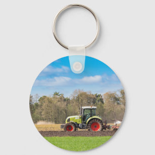 Chaveiro Fazendeiro no trator que ara o solo arenoso no