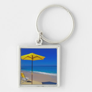 Chaveiro Guarda-chuva de praia amarelo e cadeiras em praia 