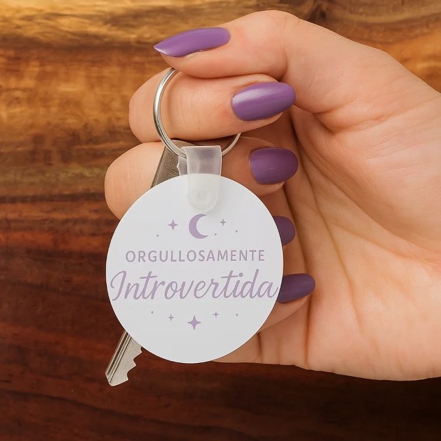 Chaveiro Llavero redondo “Orgullosamente introvertida”  (Una mano de mujer con sus uñas pintadas de morado cogiendo unas llaves con su llavero favorito.)