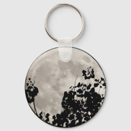 Chaveiro Lua atrás das folhas escuras