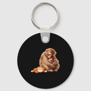 Chaveiro Meme do macaco socando o animal de pelúcia abraçad